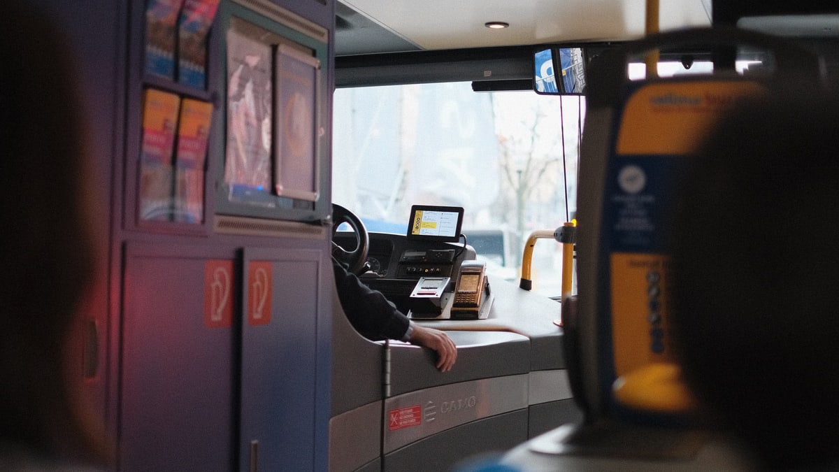 A modern bus interior showcasing the driver's area during daylight hours.